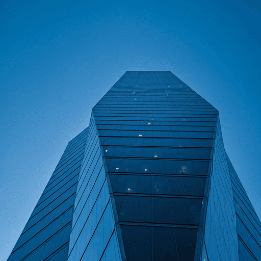 Dramatic low angle shot of a towering glass skyscraper